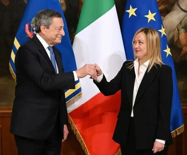 10月23日，在意大利罗马，新任总理焦尔吉娅·梅洛尼（右）从前总理德拉吉手中接过主持内阁会议的铃铛