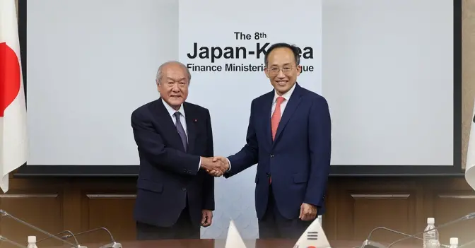 今年6月，韩国财长秋庆镐（右）和日本财务大臣铃木俊一举行峰会/韩联社