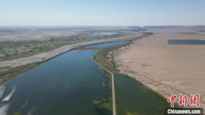 5月27日，位于甘肃张掖市高台县黑河湿地保护区的荒漠与湿地共生共美。该保护区南依祁连山国家级自然保护区，北靠巴丹吉林沙漠，处于河西走廊“蜂腰”地带，是中国西北地区自然保护区网络的重要节点。图为荒漠与湿地尽显生态美。（无人机图片）戴文昌　摄