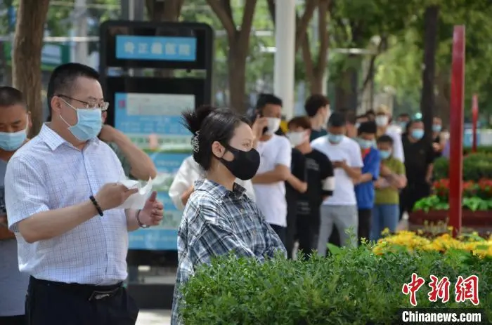 兰州高新区某核酸检测点居民正在排队等待核酸检测。图片来源：中新网