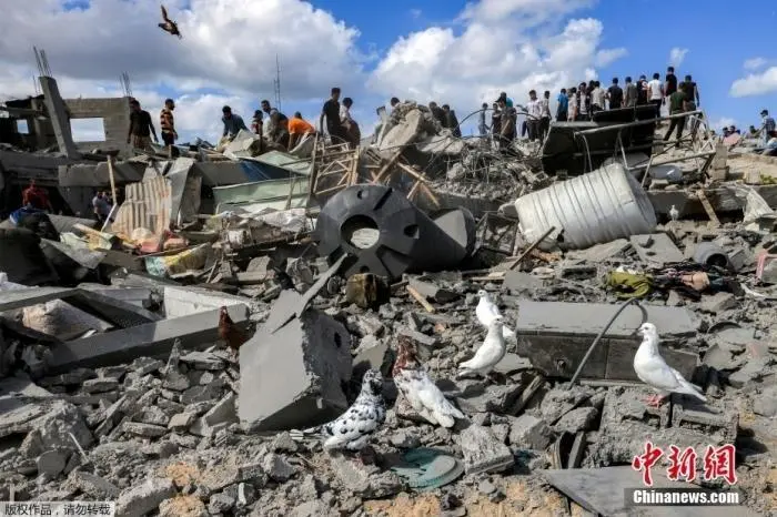 当地时间10月18日，巴勒斯坦加沙地带，汗尤尼斯被以色列轰炸后，人们检查被毁建筑的残骸。