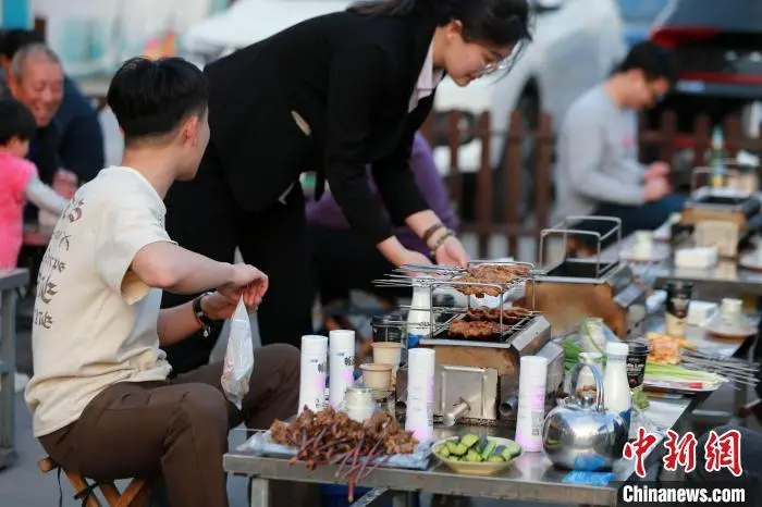 山东淄博，食客正在享用烧烤。 中新社 记者梁犇摄