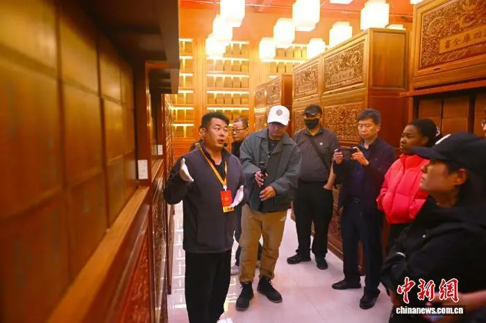 图为工作人员向采访团成员介绍《钦定四库全书》　中新社记者　李亚龙　摄