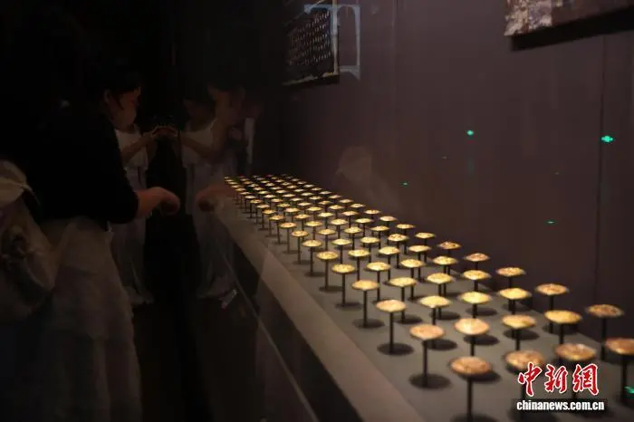 8月31日，江西南昌，游客在南昌汉代海昏侯国遗址博物馆参观展出的金饼等文物。暑假尾声将至，南昌汉代海昏侯国遗址博物馆热度不减。游客们利用假期最后的时光，前来感受穿越两千年的历史文化魅力。中新社记者 刘占昆 摄