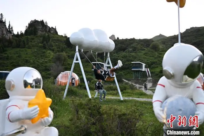 7月10日，图为游客体验则岔石林景区民宿间打造的“云朵秋千”。九美旦增　摄