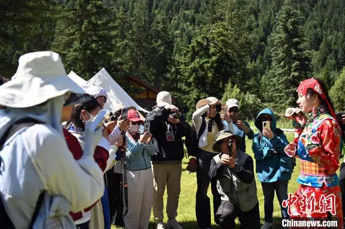 图为采访团成员聆听“三格毛”服饰的讲解　九美旦增　摄