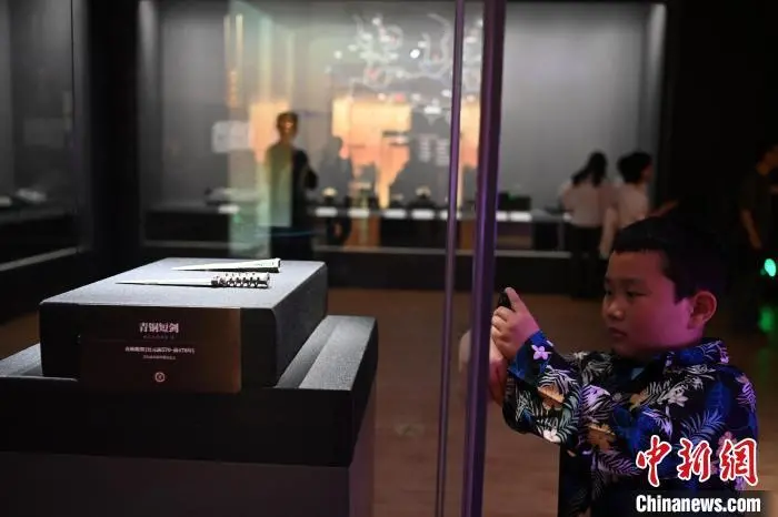 图为小朋友拿电话手表拍摄展品　中新社记者　九美旦增　摄