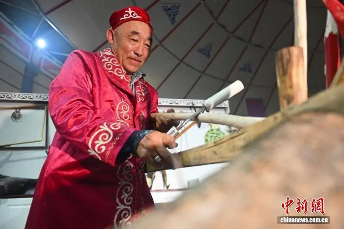 7月30日，在位于甘肃省酒泉市阿克塞哈萨克族自治县民族文化体验中心内，哈萨克族传统毡房制作技艺传承人哈哈尔曼·阿比旦进行毡房组件制作。中新社记者　李亚龙　摄