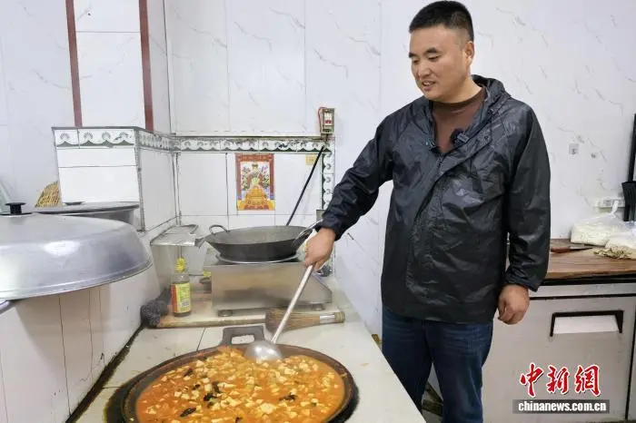 圖為龐富強在自家廚房為留守老人做飯。 梅鐿瀧 攝