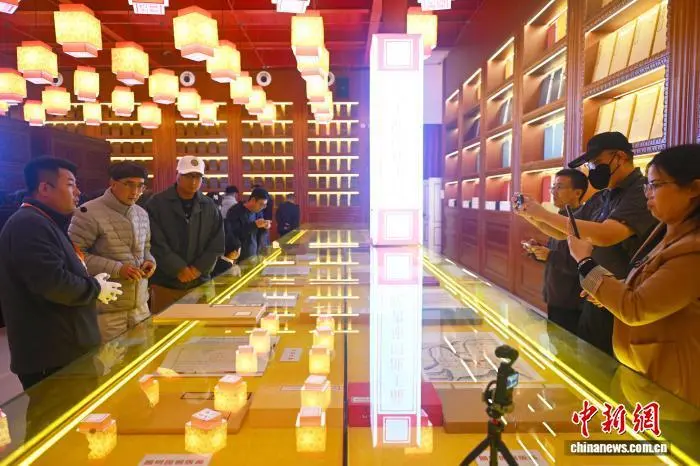 图为工作人员向采访团成员介绍龙王池四库书院典籍　中新社记者　李亚龙　摄