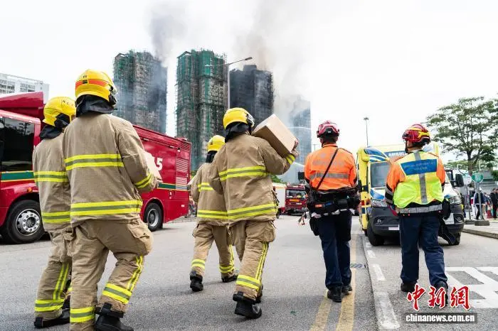图为增援轮替的消防救援人员携带物资前往火灾现场。　 中新社记者 侯宇 摄
