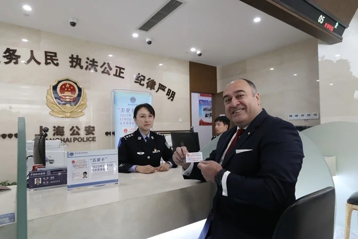 12月1日，外籍人士伊尔马兹斯南在上海市公安局出入境管理局办证大厅领取新版永居证“五星卡”。新华社方喆 摄