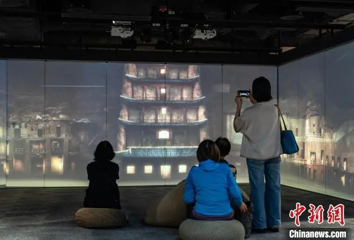 图为观众在展区内欣赏讲述敦煌故事的视频　中新网记者　侯宇　摄