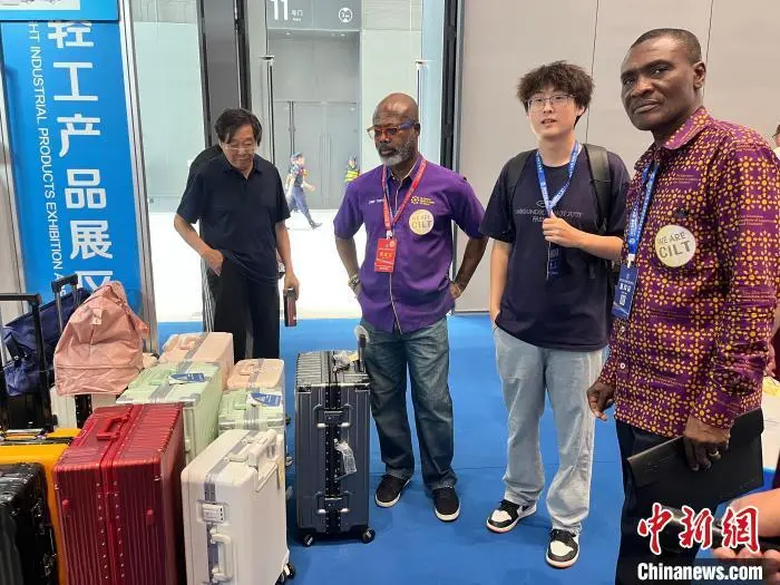 6月18日，蒂特·奥乌苏-诺特(左二)在廊坊经洽会挑选行李箱。　　董皓楠 摄