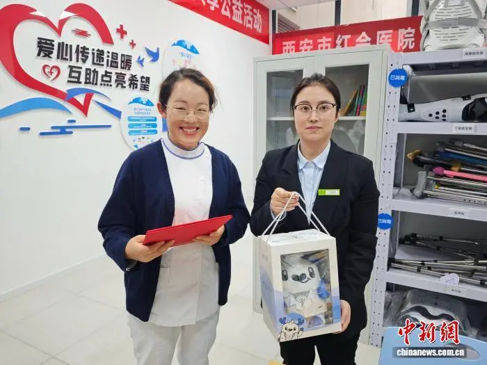 图为工作人员为捐赠者颁发爱心证书、赠送玩偶。党田野 摄