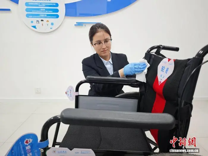 图为工作人员正在擦拭轮椅。党田野 摄