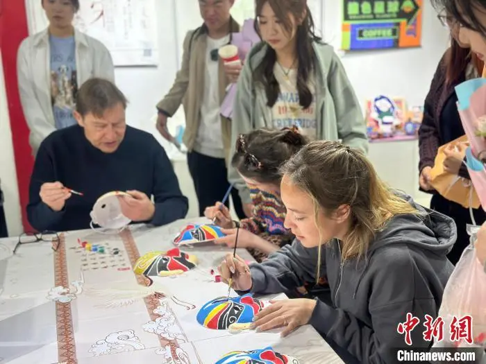4月10日，英国剑桥莎士比亚戏剧团的演员们在燕京理工学院体验脸谱绘制。　刘伟 摄