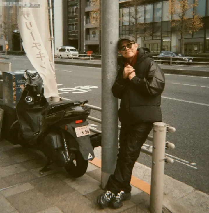 李连杰INS晒日本旅游照：手拿佛珠半靠栏杆拍照，晒着阳光好惬意