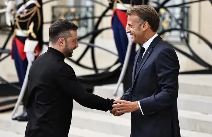 2025年9月4日，在法国首都巴黎的总统府爱丽舍宫，法国总统马克龙（右）迎接出席“志愿联盟”线上会议的乌克兰总统泽连斯基。新华社记者 高静 摄