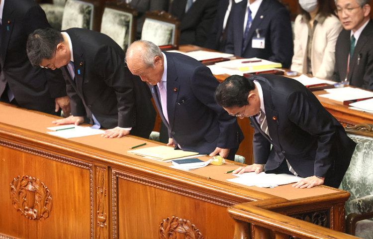 当地时间12月13日，在东京国会众议院全体会议上，日本首相岸田文雄(右)和他的内阁成员低下了头。图自视觉中国