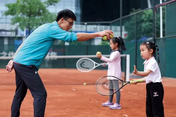 2023年4月8日，广州，在红土球场参加网球培训的孩子。（图/高菲）