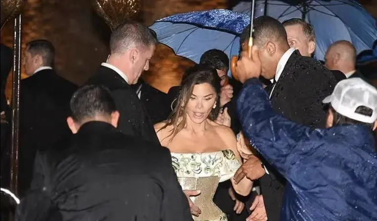 雨中发型凌乱的新娘桑切斯只好在数顶雨伞的护送下登船离开