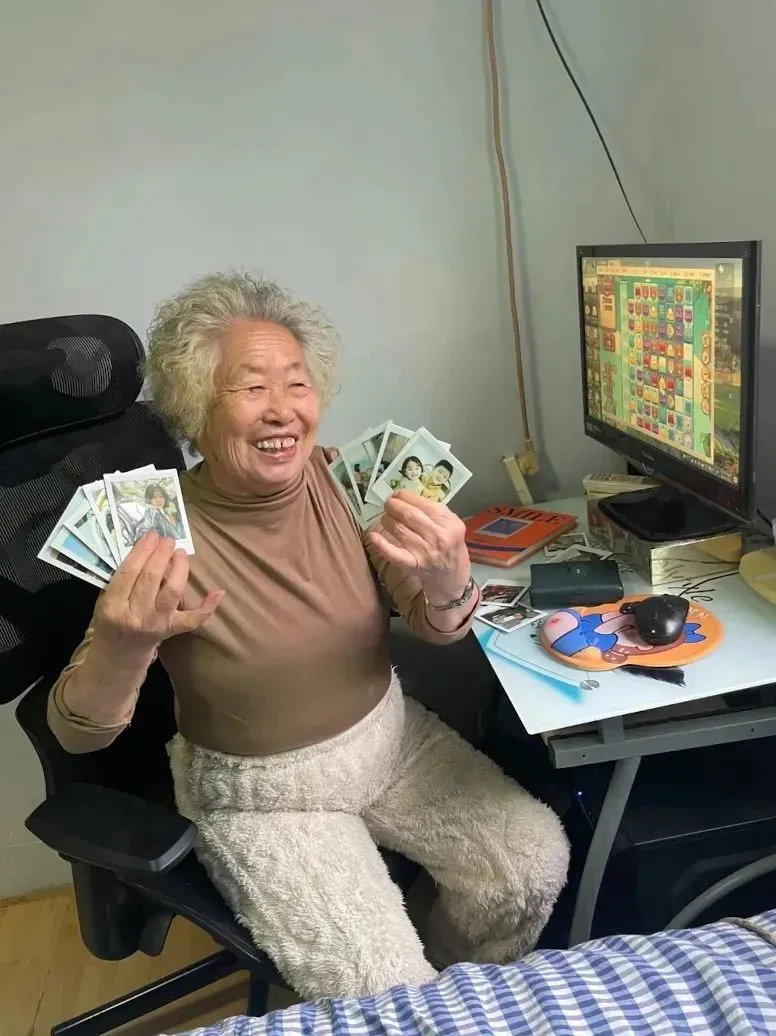 阿珍拿著家人的照片笑得很開心