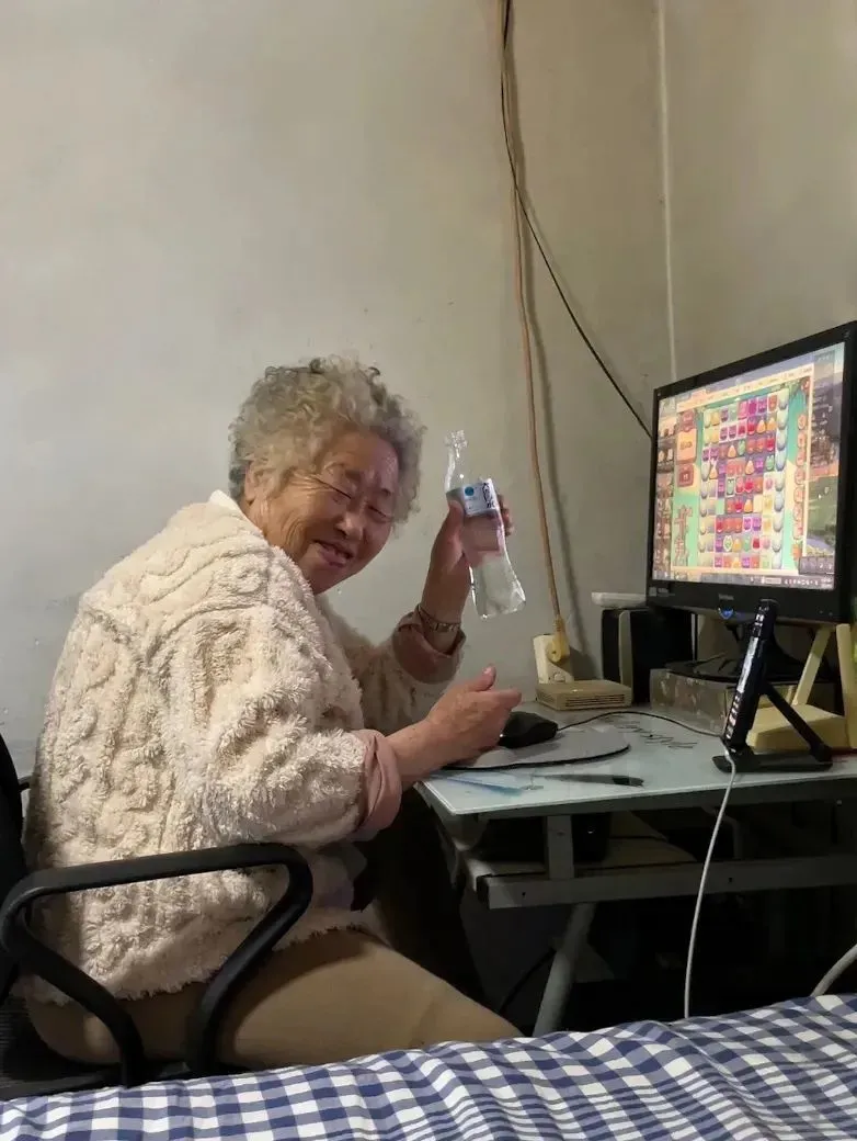 邊喝汽水邊玩遊戲的阿珍很開心