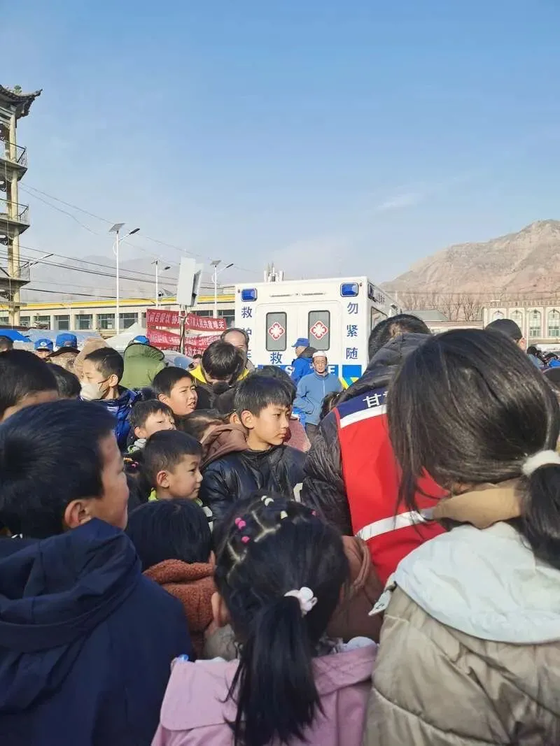 12月21日，大河家镇安置点，一名医务人员正在给孩子们讲解防震知识。中青报·中青网记者 尹海月/摄