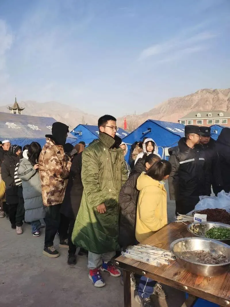 12月21日9时许，村民们正在大河家镇安置点排队领取餐食。中青报·中青网记者 尹海月/摄