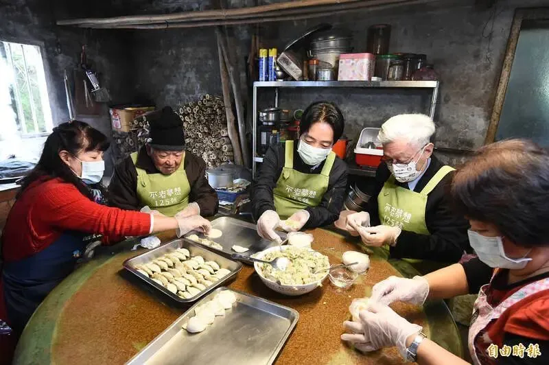 副總統賴清德(中)今25日於金山下廚包水餃、陪近百歲人瑞夫妻圍爐過年。(記者塗建榮攝)