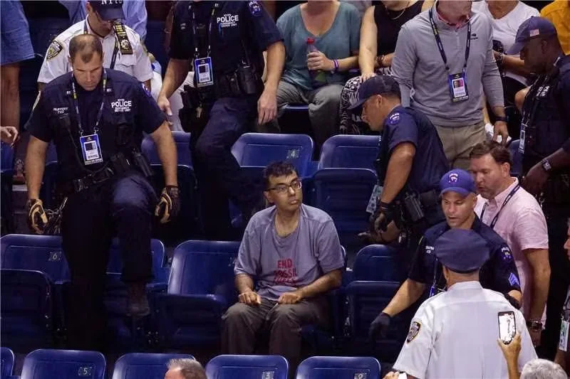 报道称，抗议者将脚粘在体育场看台的地板上，导致安保人员花了很长时间将其带离。