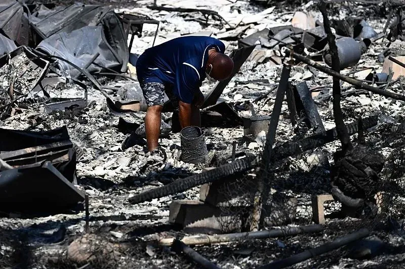 8月11日，夏威夷拉海纳，大火过后，当地居民看着自家房子变成灰烬。图源：视觉中国