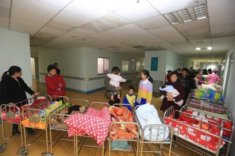 ●2016年10月29日，在襄阳市第一人民医院产科，家长们推着婴儿车排起长队，等候护士给新生儿做护理。