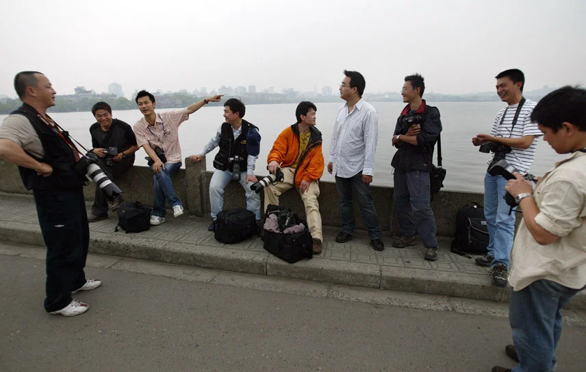 当年，“初代同事”们一起在西湖断桥等一场雨。受访者供图