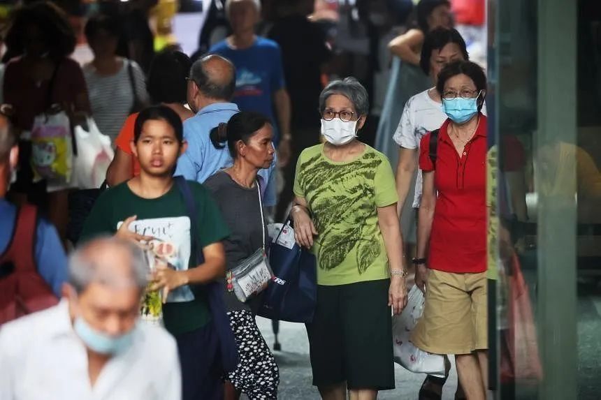 近日，新加坡街头，不少民众戴口罩出行。图源/Bloomberg