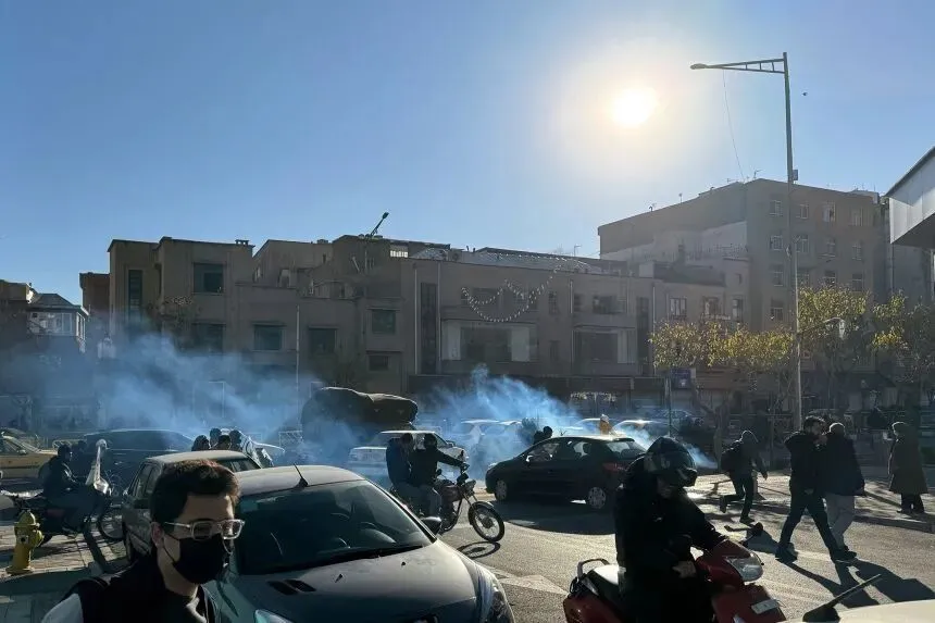 Iranian shopkeepers and traders protest against economic conditions as tear gas is fired by anti-riot police in Tehran, Iran, on Monday.