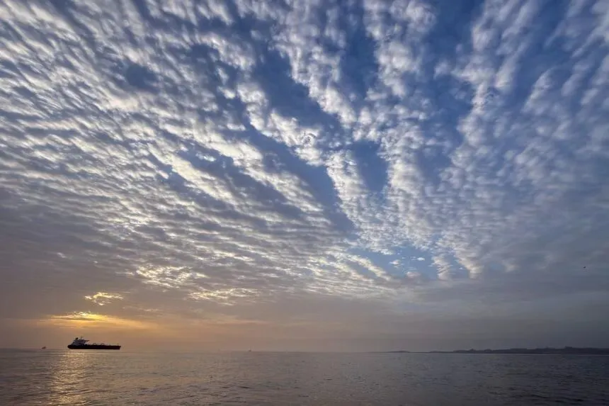 4月18日，太阳在伊朗克什姆岛海岸外的霍尔木兹海峡停泊的一艘油轮后方升起。