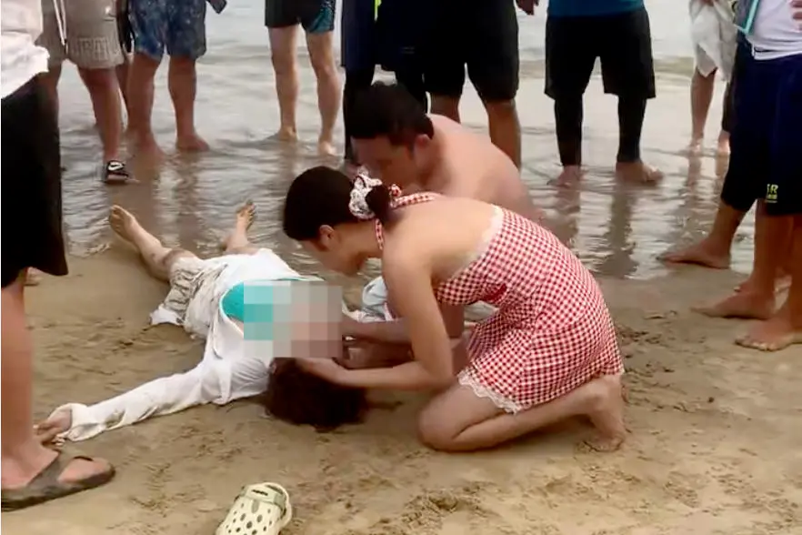 ▲姜智文、袁苑夫妻俩守护已经复苏的溺水者。视频截图