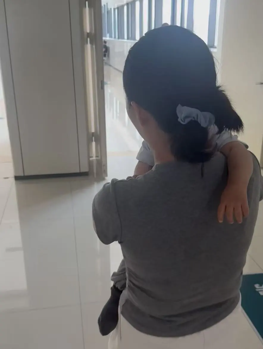 △李女士抱着孩子。