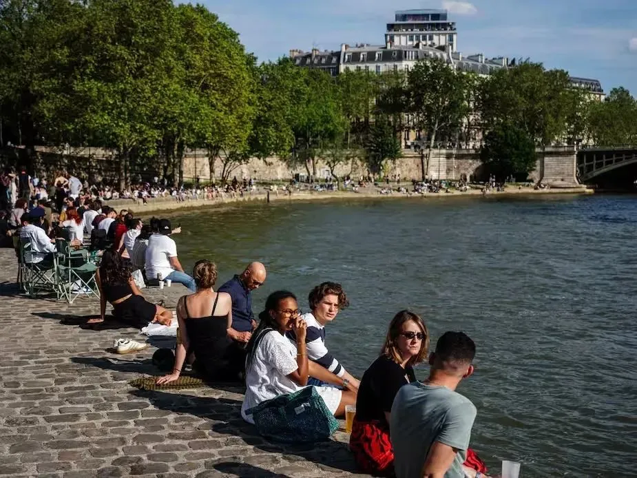 塞纳河畔坐着的巴黎市民与游客