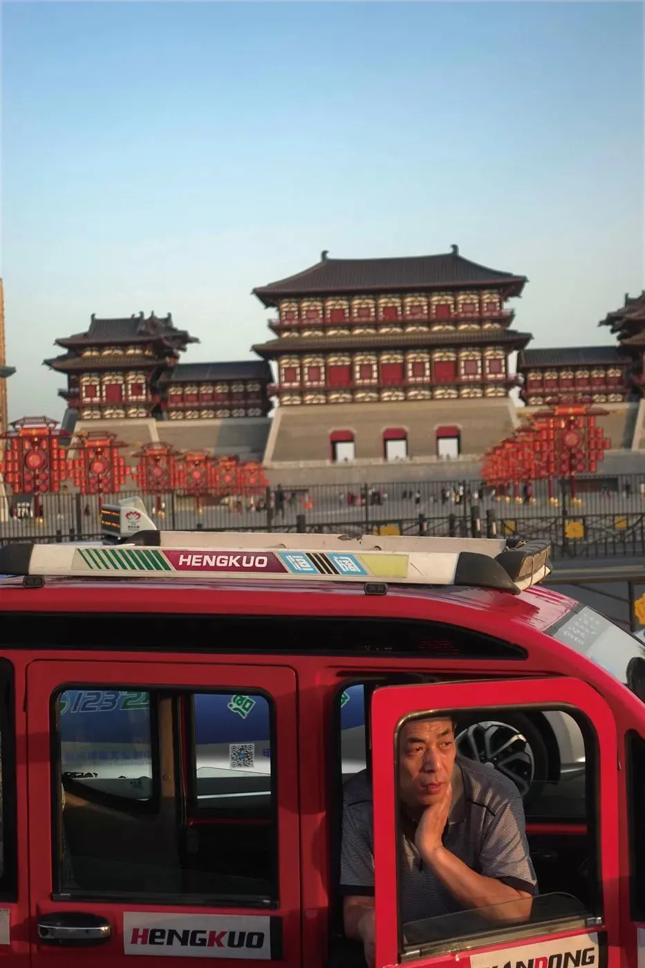 △男子在洛阳明堂天堂景区门口拉客，身后是重建的应天门。(图/苏峥 ）