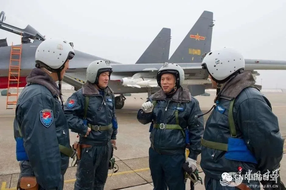 景建峰(右二)飞行结束后与飞行员交流（来源：中国空军）