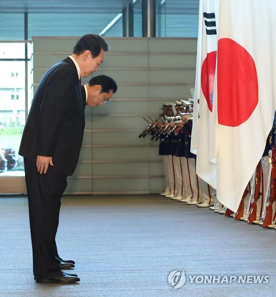 16日韩日领导人峰会前，尹锡悦和日本首相岸田文雄向两国国旗鞠躬致敬。图源：韩联社