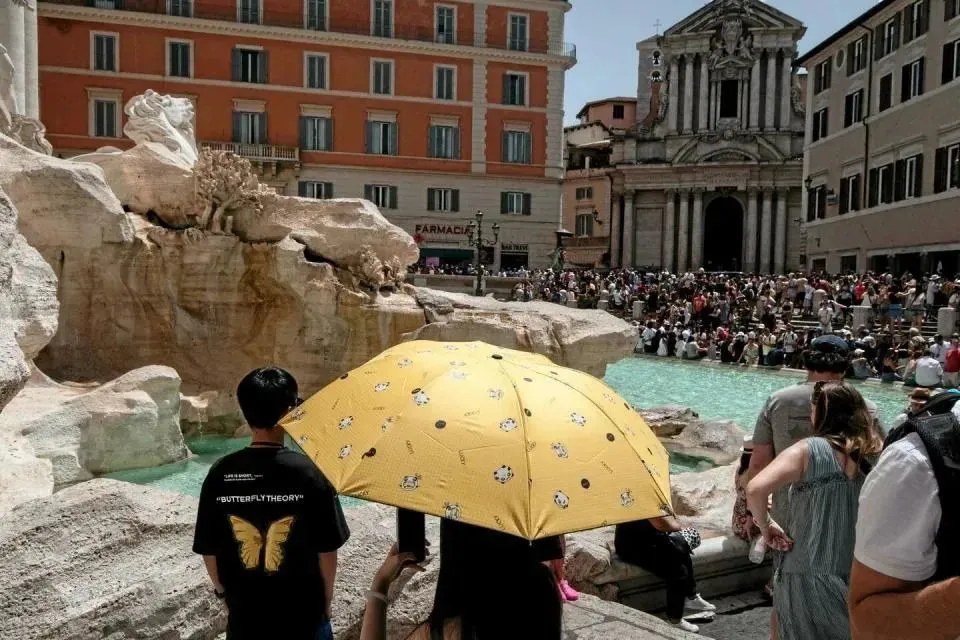 ▲ 天气太热，罗马的游客聚在喷泉旁避暑。（法新社图）