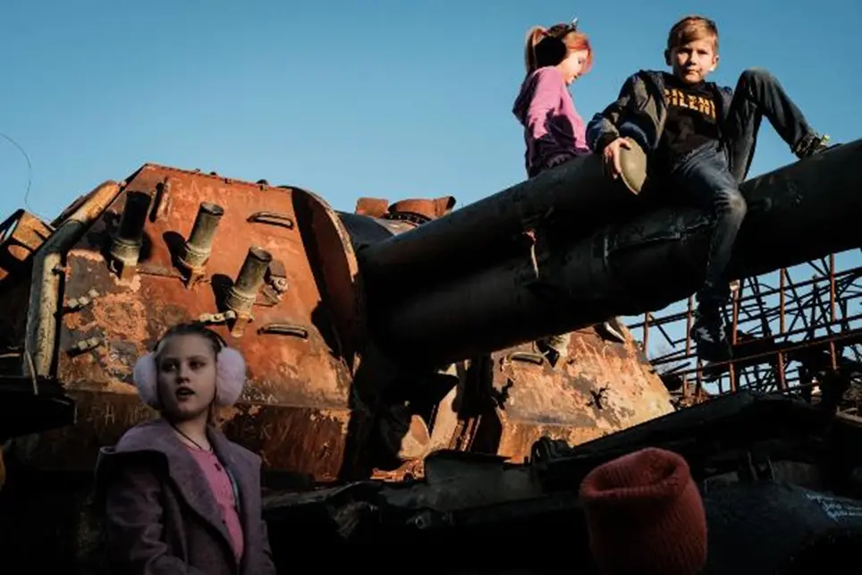 10月16日，在乌克兰基辅举行的被毁军车露天展览期间，孩子们爬上一辆被毁坏的俄罗斯坦克。图源： 盖蒂图片社