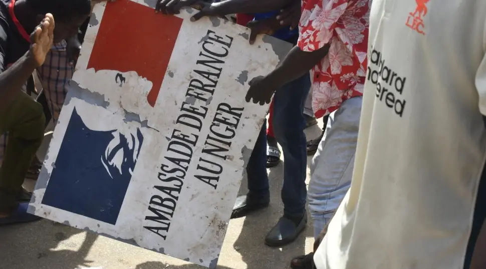 7月30日，尼日尔民众在首都尼亚美举行支持军政府的集会游行，游行人士手持从法国大使馆取下的标牌