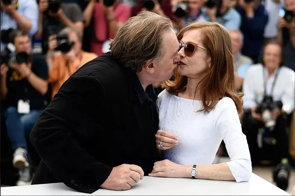▲ 2015年戛纳电影节，电影《爱之谷》演员拍照时间，德帕迪约偷吻于佩尔，被后者闪躲过去，最终只亲吻到于佩尔的脸颊。（法新社图）
